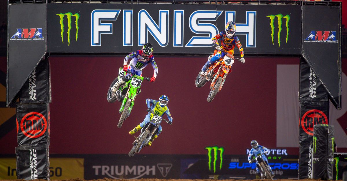 Multiple Supercross bikes going through the finish line jump