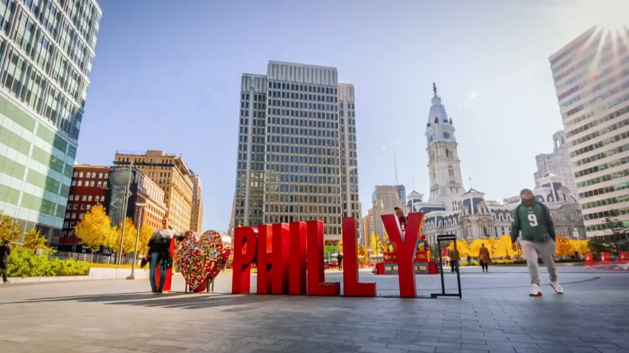 Screengrab of people walking by the word "Philly" in the middle of a city